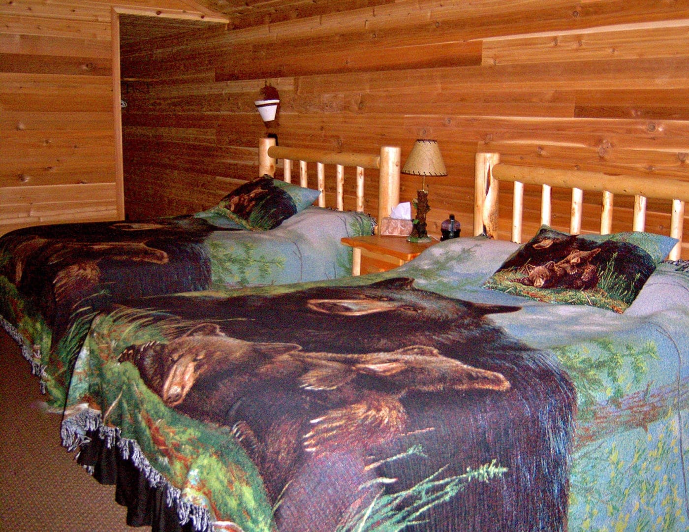 Guest room with double beds in a black bear theme.