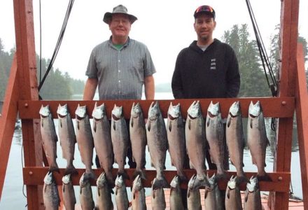 Two men displaying their salmon catch