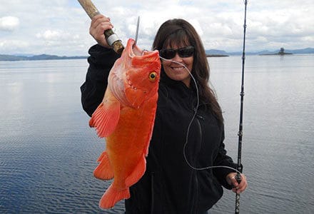Female guest holds up yelloweye rockfish catch.