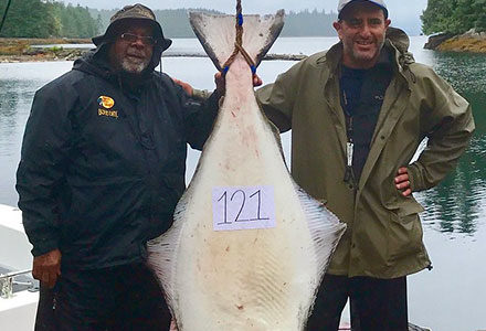 Two guests pose with their 121 pound halibut.
