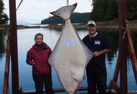 Guest couple pose with 196 pound halibut catch.