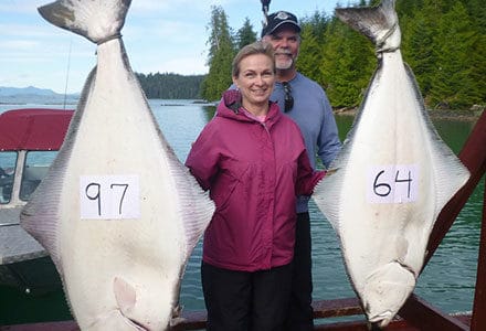 Guest couple poses with their 97 and 64 pound halibut.