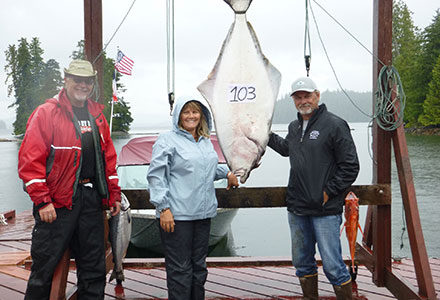 Three guests pose with 103 pound halibut.