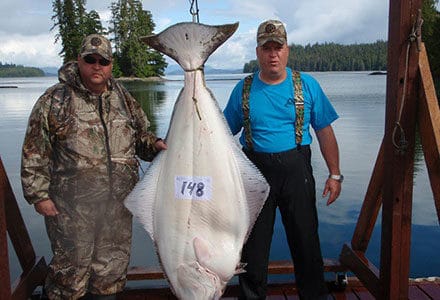 Two guests pose with 148 pound halibut catch.