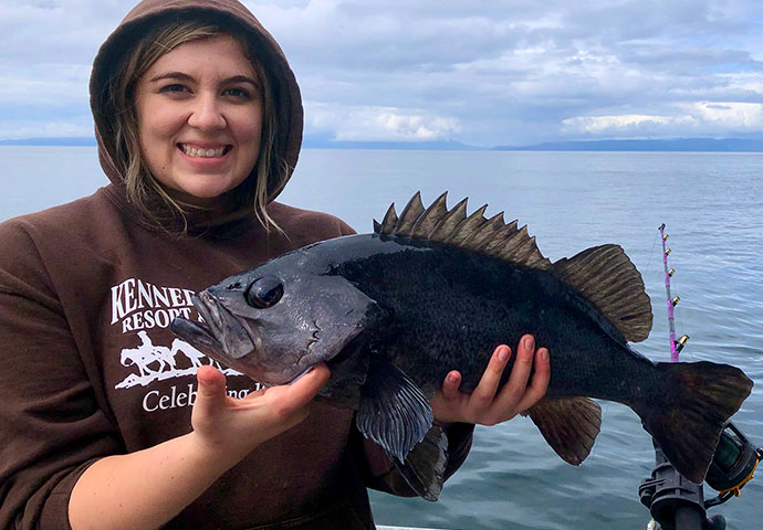 Woman holds beautiful black rockfish.