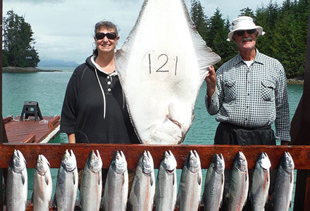 Guest couple pose with their 121 pound halibut and king salmon catch.