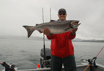 Guests holds up nice king salmon on the fishing boat.