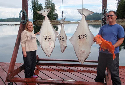 Guest couple poses with their yelloweye rockfish and three halibut - 77 pounds, 23 pounds and 109 pounds.