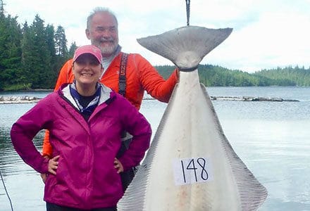 Couple poses with their 148 pound halibut catch