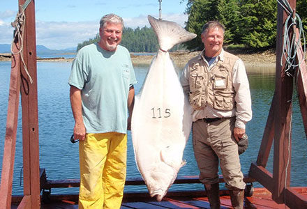 Two male guests pose with their 115 pound halibut.