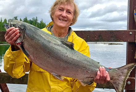 Woman holds a large king salmon catch.