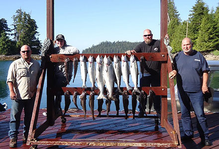 Three guests pose with their king salmon and rockfish catch.
