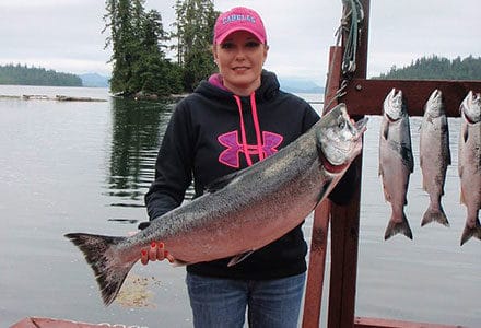 A female guest poses with her king salmon catch.