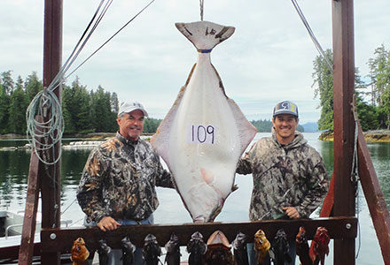 Group poses with their catch, including a 109 pound halibut.