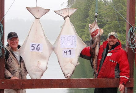 Two guests pose with their ling code and 56 pound and 49 pound halibut catches.