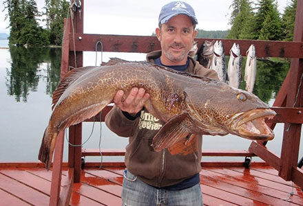 A guest poses with his huge ling cod catch.