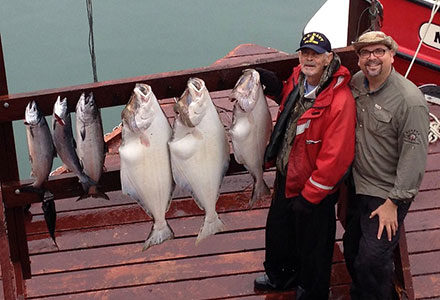 Two guests pose with their halibut and king salmon.