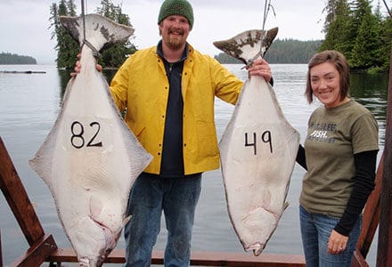 Guest couple pose with their 82 and 49 pound halibut.