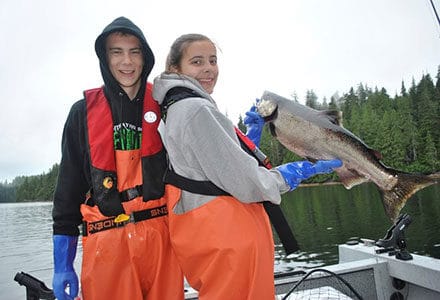 Teenage brother and sister pose with their salmon catch.
