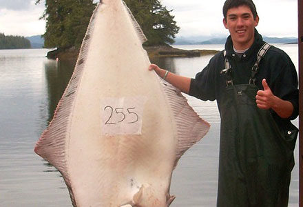 Crewmember poses with his 255 pound halibut!