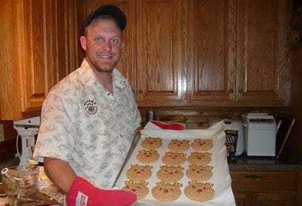 Crewmember shows off cookies he baked in the kitchen.